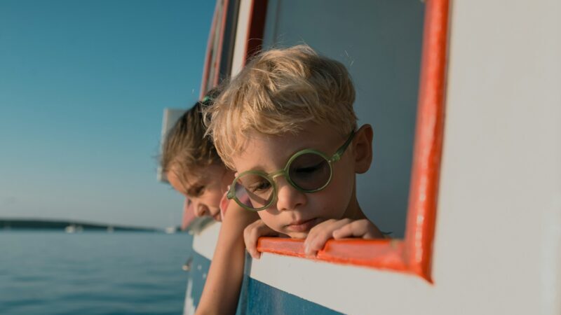 船から海をのぞく子供の夏のフランス旅行の風景