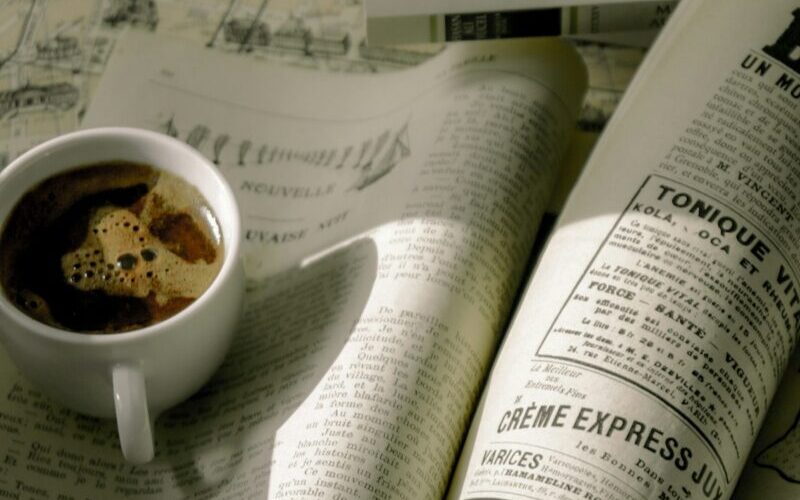 フランス語の新聞とコーヒーが乗った勉強中のテーブルの上